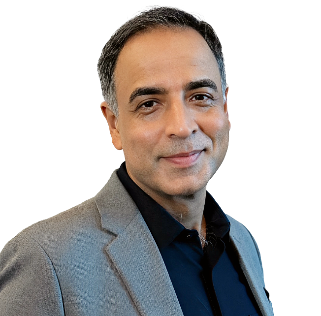 Portrait of a man wearing a light gray blazer and dark shirt, smiling at the camera against a white background.